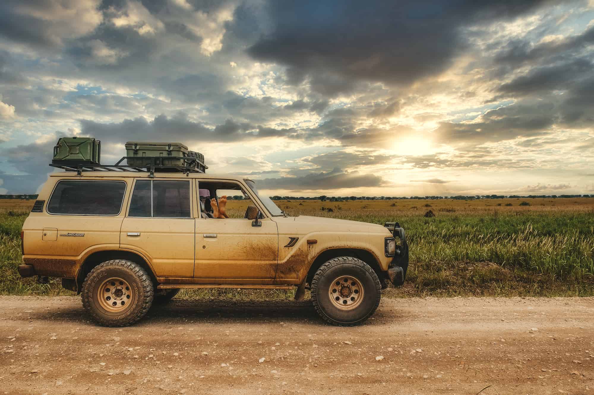 Natasha's Feet On Window Of Parked Land Cruiser In Uganda Dirt Road